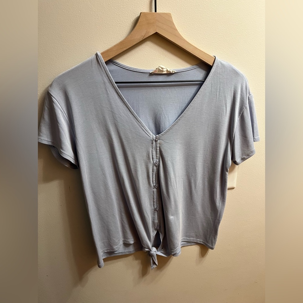Button down short- sleeve with tie details at bottom.